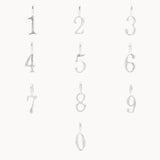 Set of silver number pendants from 0-9 on a white background