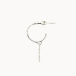 side view of a silver hoop earring with a drop detail on a white background