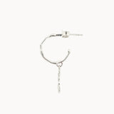 side view of a silver hoop earring with a drop detail on a white background