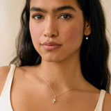 woman wearing open star diamond necklace and diamond earrings in yellow gold 