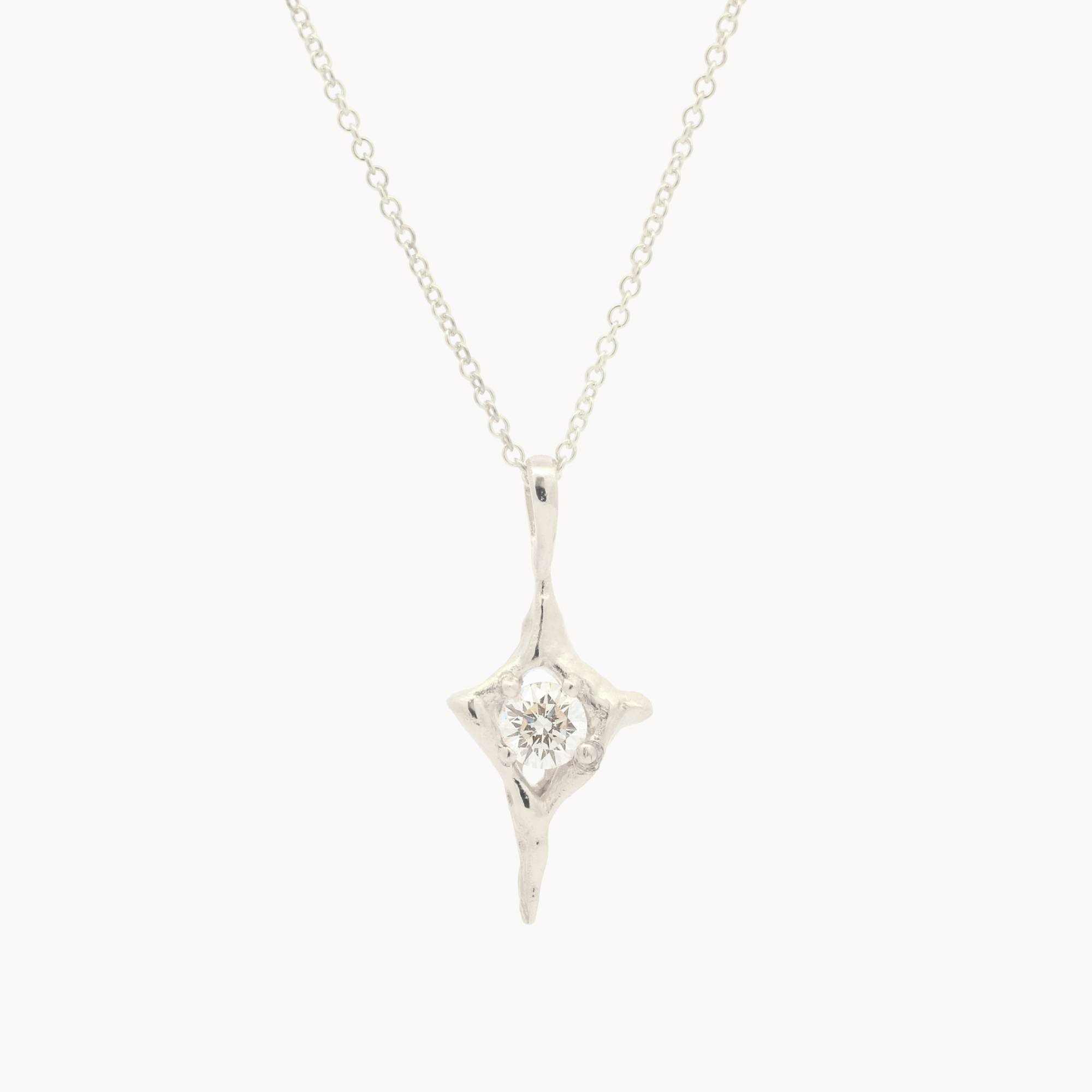 white gold four-pointed star pendant necklace with a round diamond in the middle on a white background