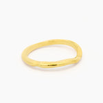 side view yellow gold wedding ring with soft curve shape at front and organic rustic texture on a white background