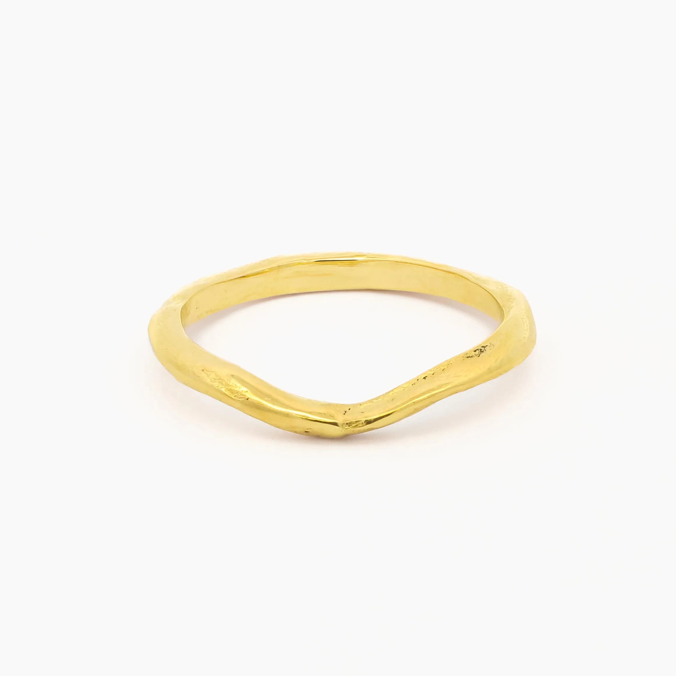 yellow gold wedding ring with soft curve shape at front and organic rustic texture on a white background