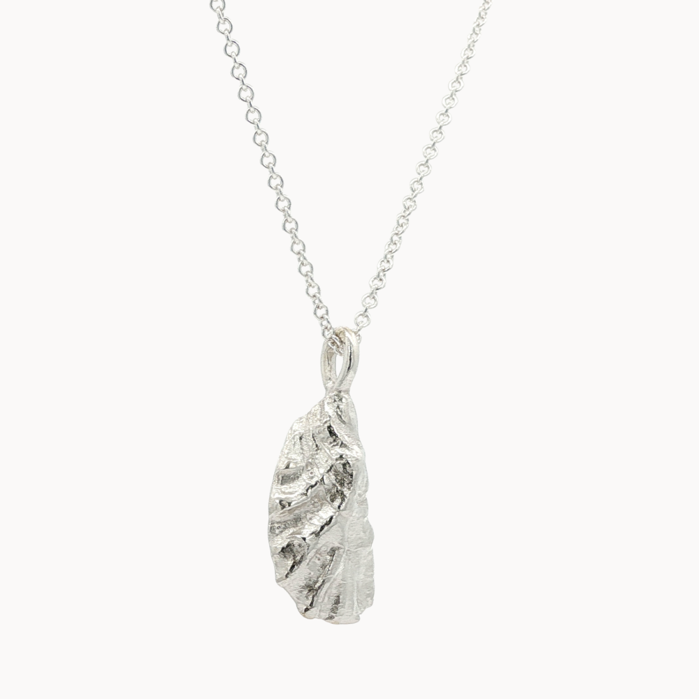 side view of silver oyster necklace with silver chain on a white background