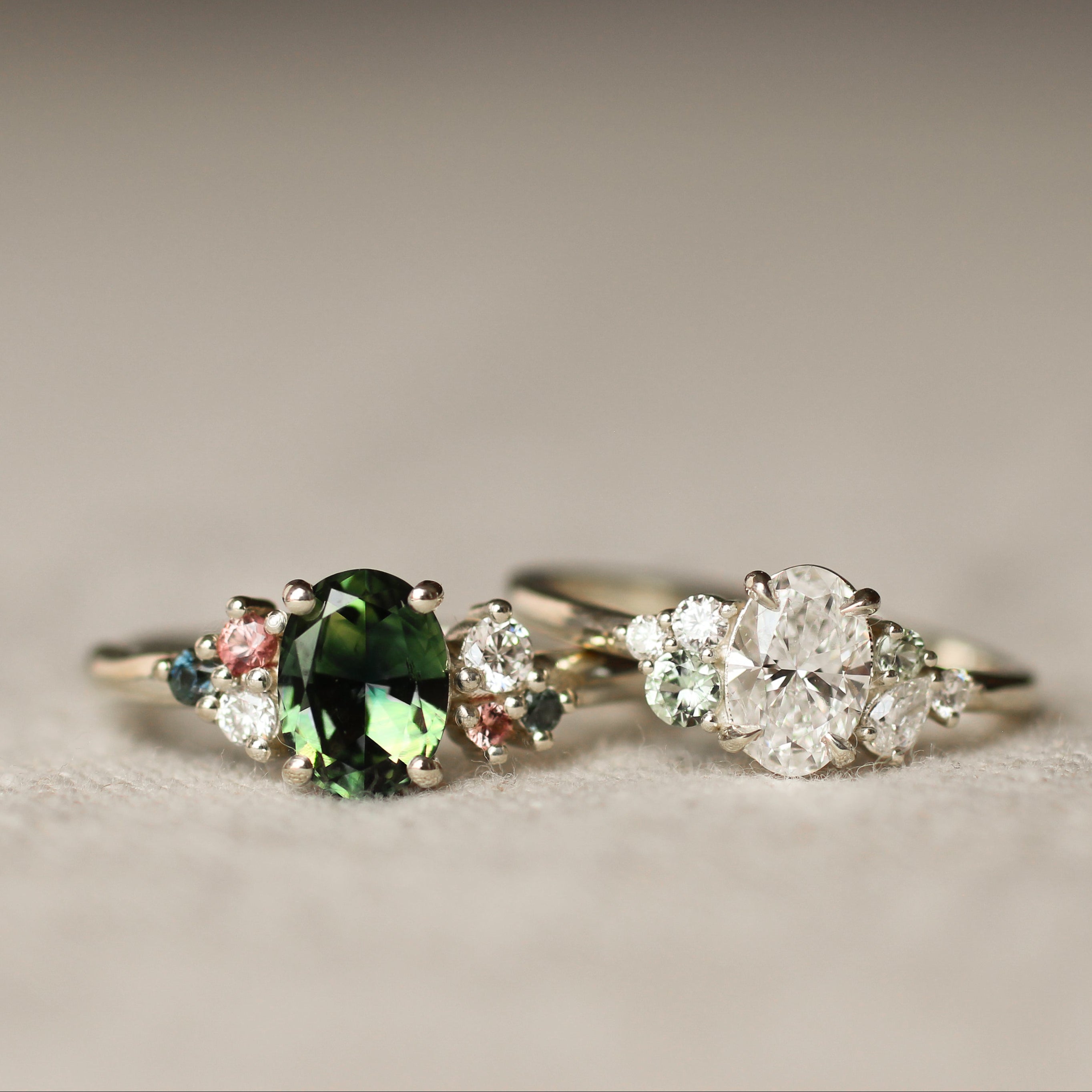 Two rings with gemstones on a textured surface