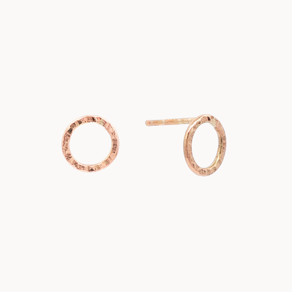 Rose gold circle stud earrings with hammered texture on a white background