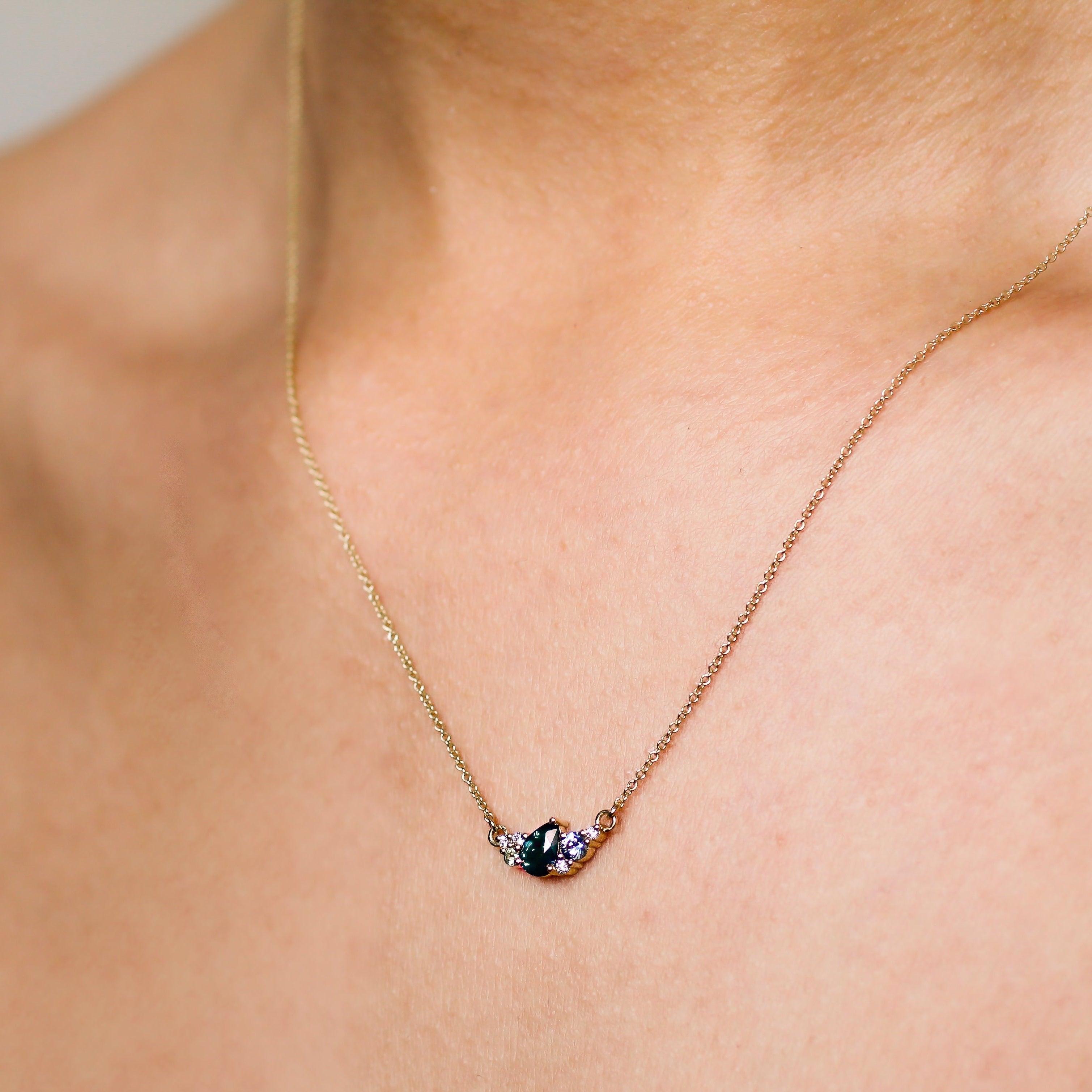 Necklace with a pendant on a person's neck against a neutral background