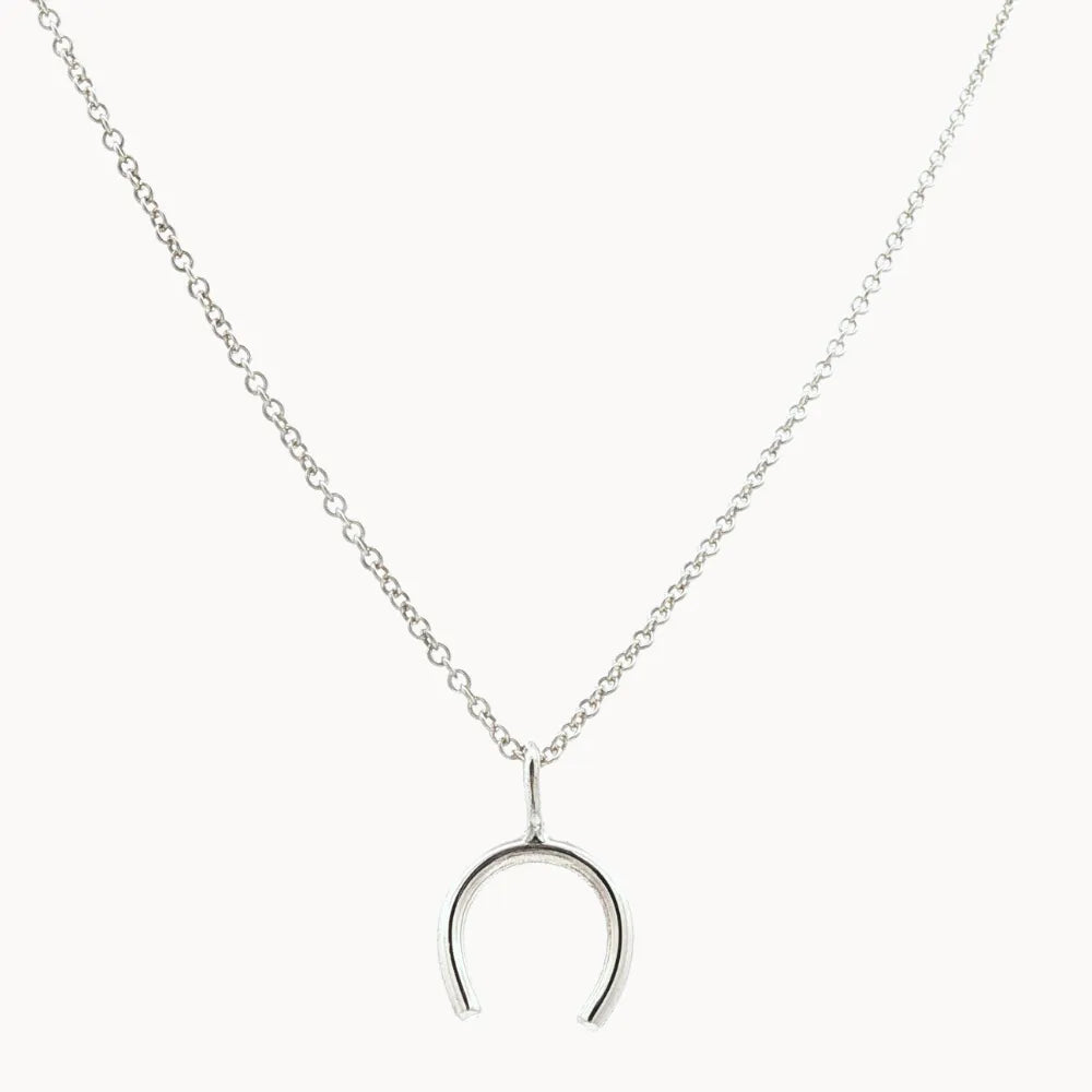 Silver wishbone horseshoe pendant necklace on a white background