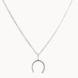 Silver wishbone horseshoe pendant necklace on a white background