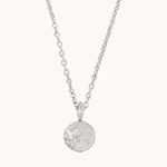 Silver necklace with a round moon and stars pendant on a white background