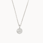 Silver necklace with a round moon and stars pendant on a white background
