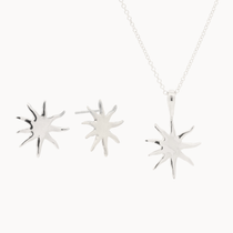 Silver sun-shaped pendant necklace and stud earrings on a white background