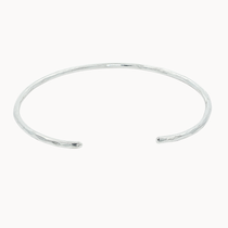 slim silver open bangle with hammered texture on a white background