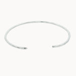 slim silver open bangle with hammered texture on a white background
