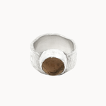 A textured silver ring with a central round smoky quartz brown stone, photographed on a clean off-white background.