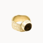 A textured gold ring with a large, polished dark brown round smoky quartz stone, photographed on a clean off-white background.