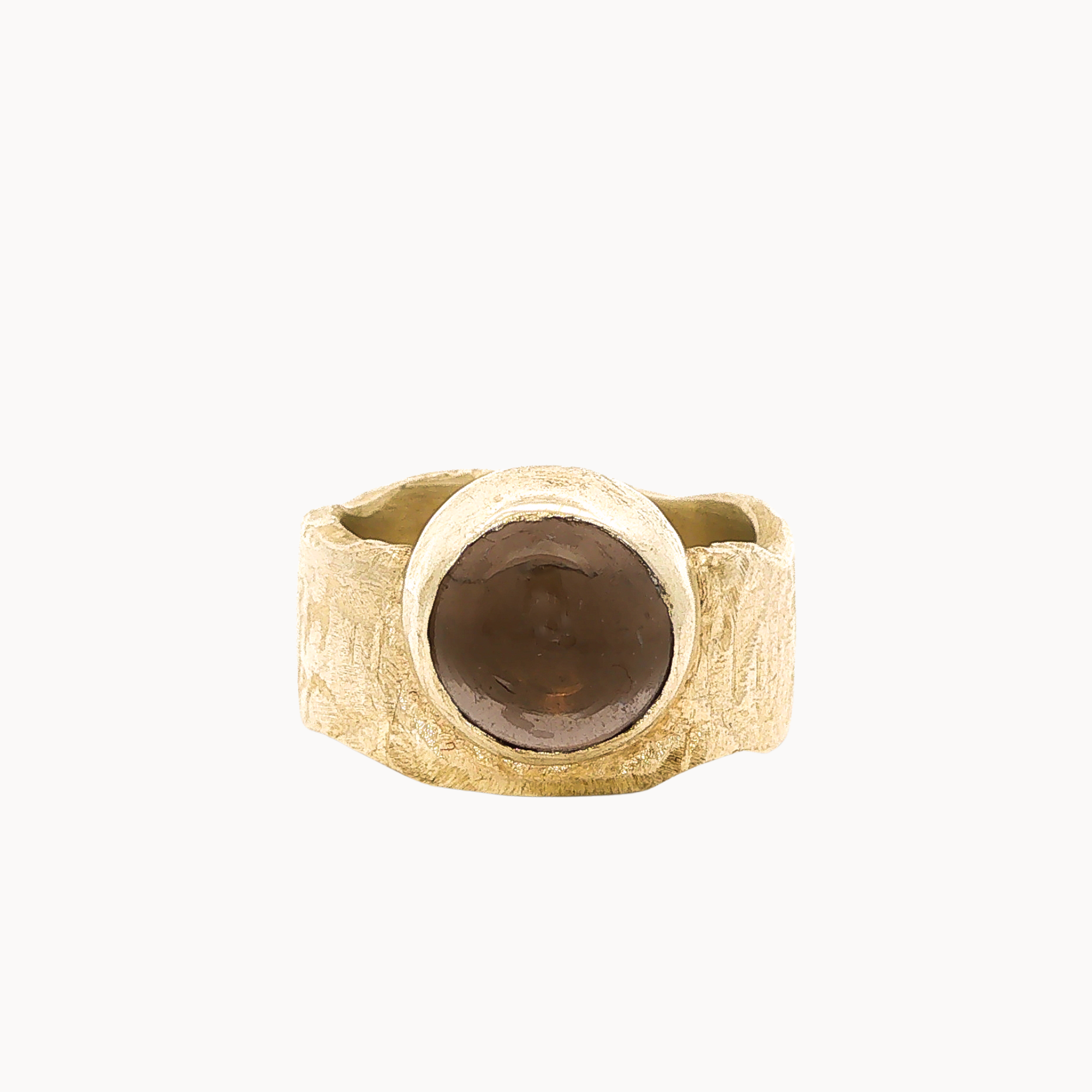 A textured gold signet-style ring with a large, smooth, round brown stone, photographed against a solid off-white background.