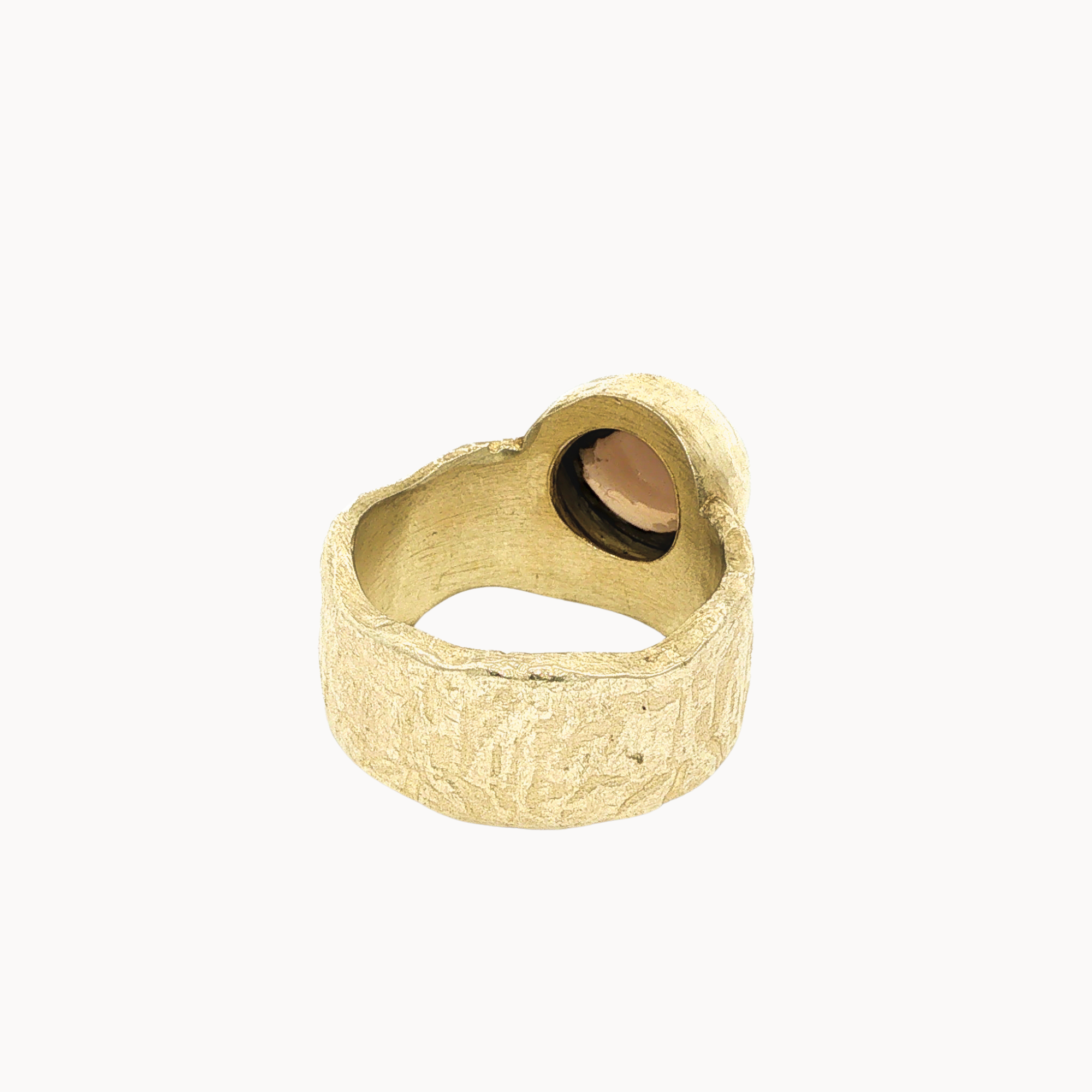 Back view of a chunky textured gold ring with a round-shaped setting and a dark smoky quartz stone, shown on a plain off-white background.