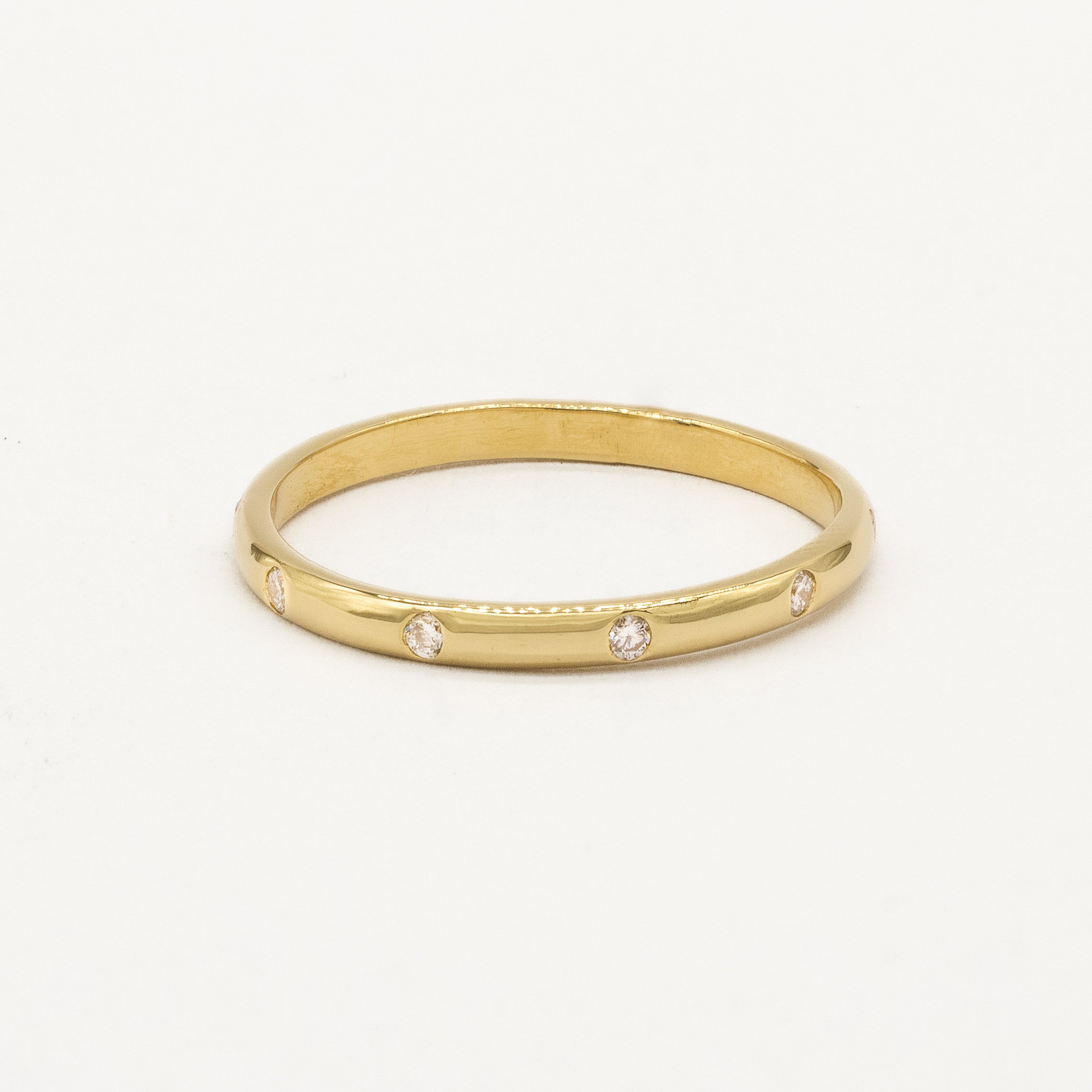 Gold ring with small diamonds on a white background
