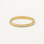 Gold ring with small diamonds on a white background
