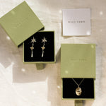 gold leo necklace and star earrings in green boxes