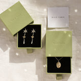 gold libra necklace and shooting star dangle earrings in green gift boxes and wild fawn care card