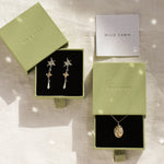 gold libra necklace and shooting star dangle earrings in green gift boxes and wild fawn care card