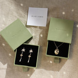 gold taurus necklace and star earrings in green gift boxes with wild fawn care card
