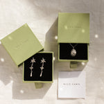 silver cancer star sign necklace, star earrings in green boxes