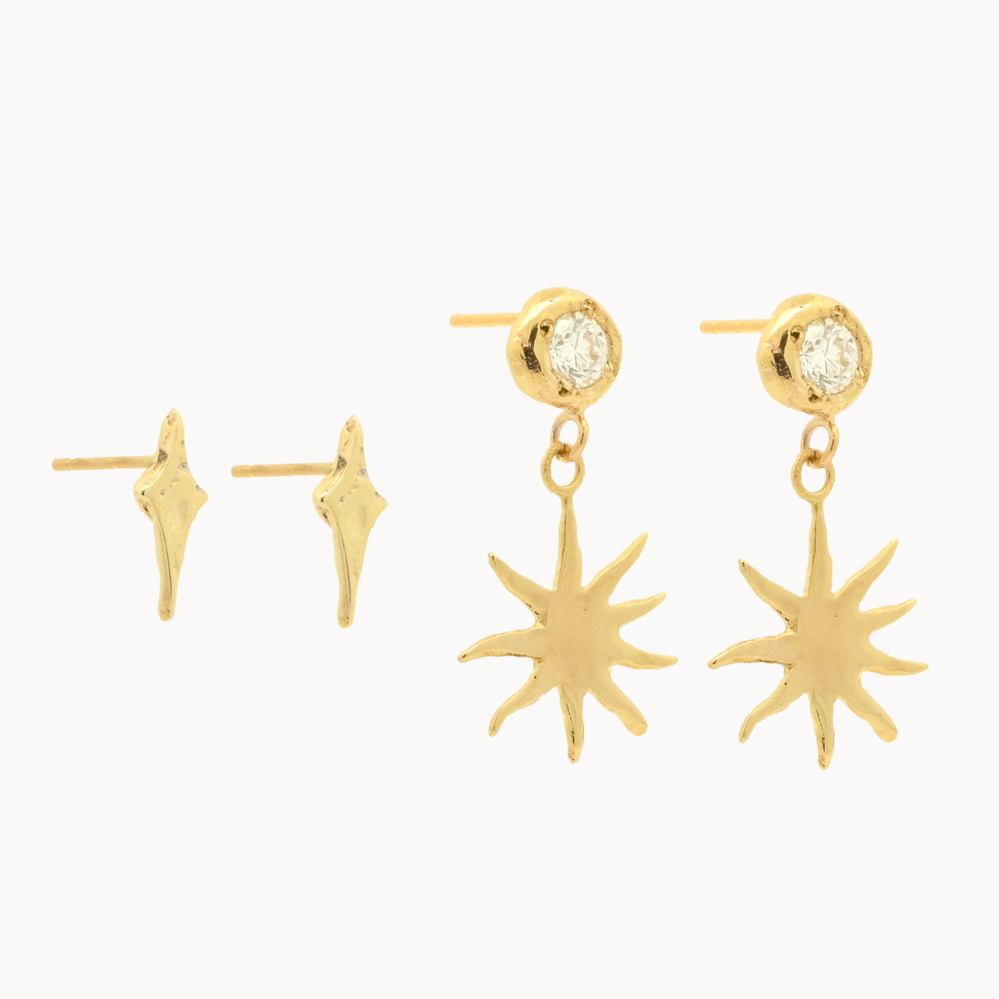 Gold earrings with four-point star and diamond sun dangle designs on a white background
