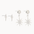 white gold star-shaped studs and diamond and sun dangle earrings on a white background