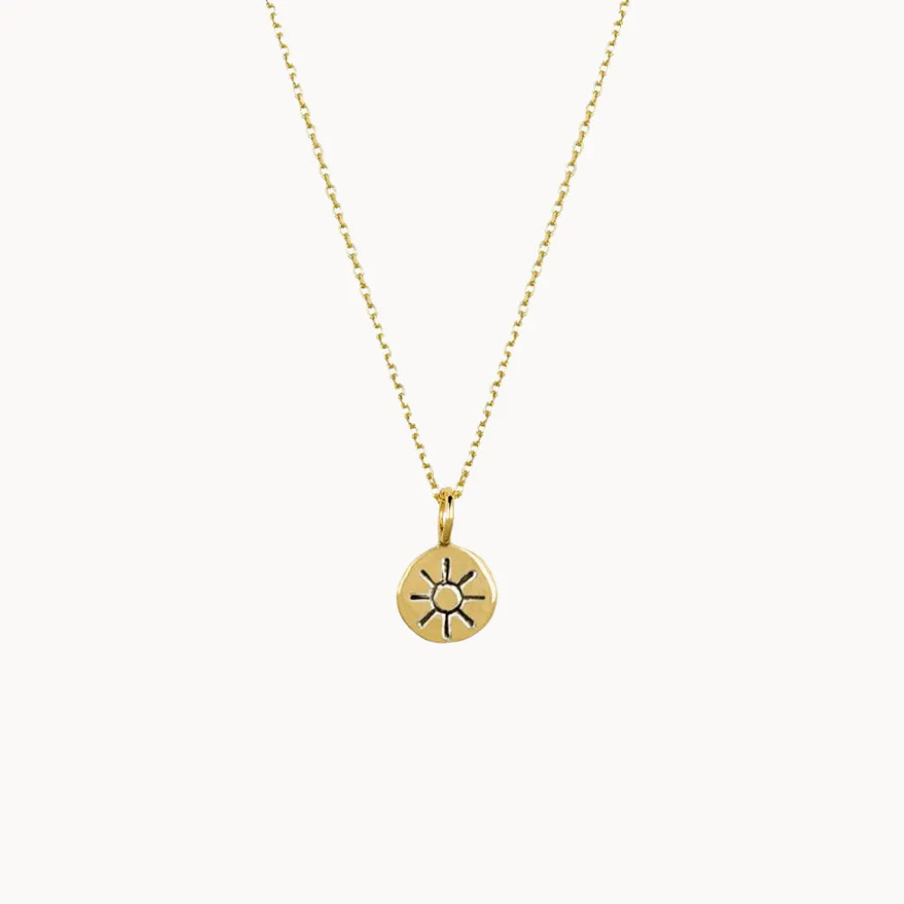 gold necklace with sunshine motif on a white background