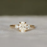 Gold ring with a three diamonds on a soft gray background