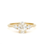 three diamond engagement ring with 14 carat gold band on a white background