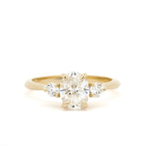 three diamond engagement ring with 14 carat gold band on a white background