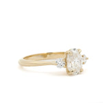 Gold trilogy engagement ring with diamonds on a white background
