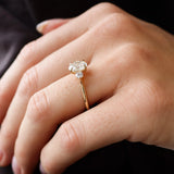 side view of a hand wearing a trilogy diamond engagement ring
