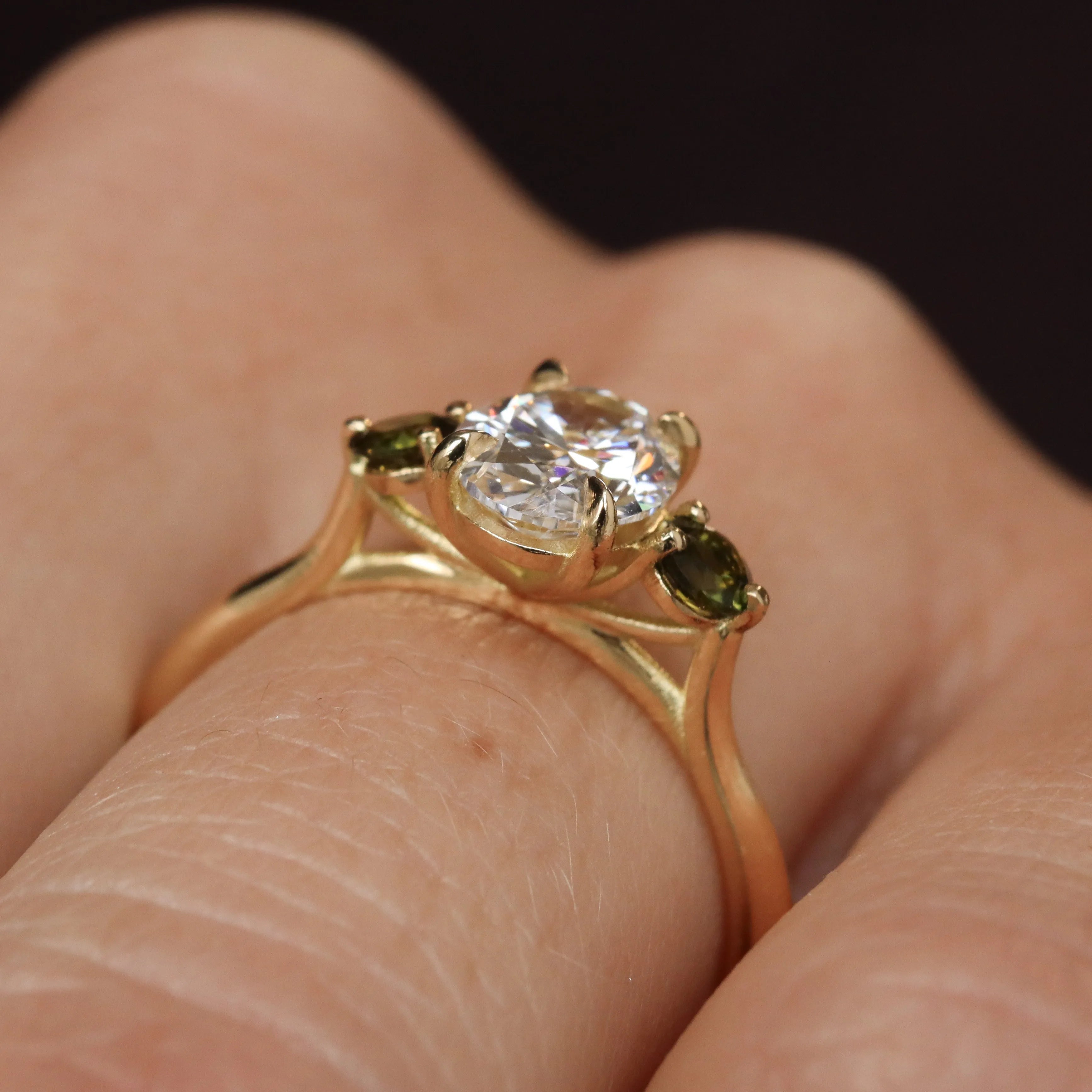 side view of wedfit engagement ring with diamond and green tourmalines