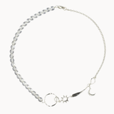 Silver necklace with star, moon, and sun charms and clear beads on a white background