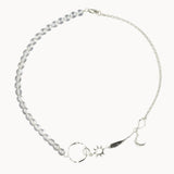 Silver necklace with star, moon, and sun charms and clear beads on a white background