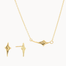 gold jewellery set including four-point star shaped studs and necklace against a white background