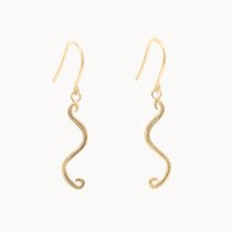 A pair of gold wavy dangle earrings with textured finishes and fishhook backings, shown against a plain off-white background.