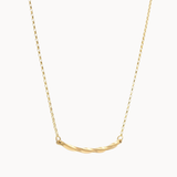 gold necklace with wavy curve pendant on white background