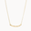 gold necklace with wavy curve pendant on white background