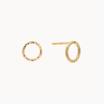 Gold circle stud earrings with hammered texture on a white background