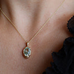 close up of bespoke gold necklace with large aquamarine pendant