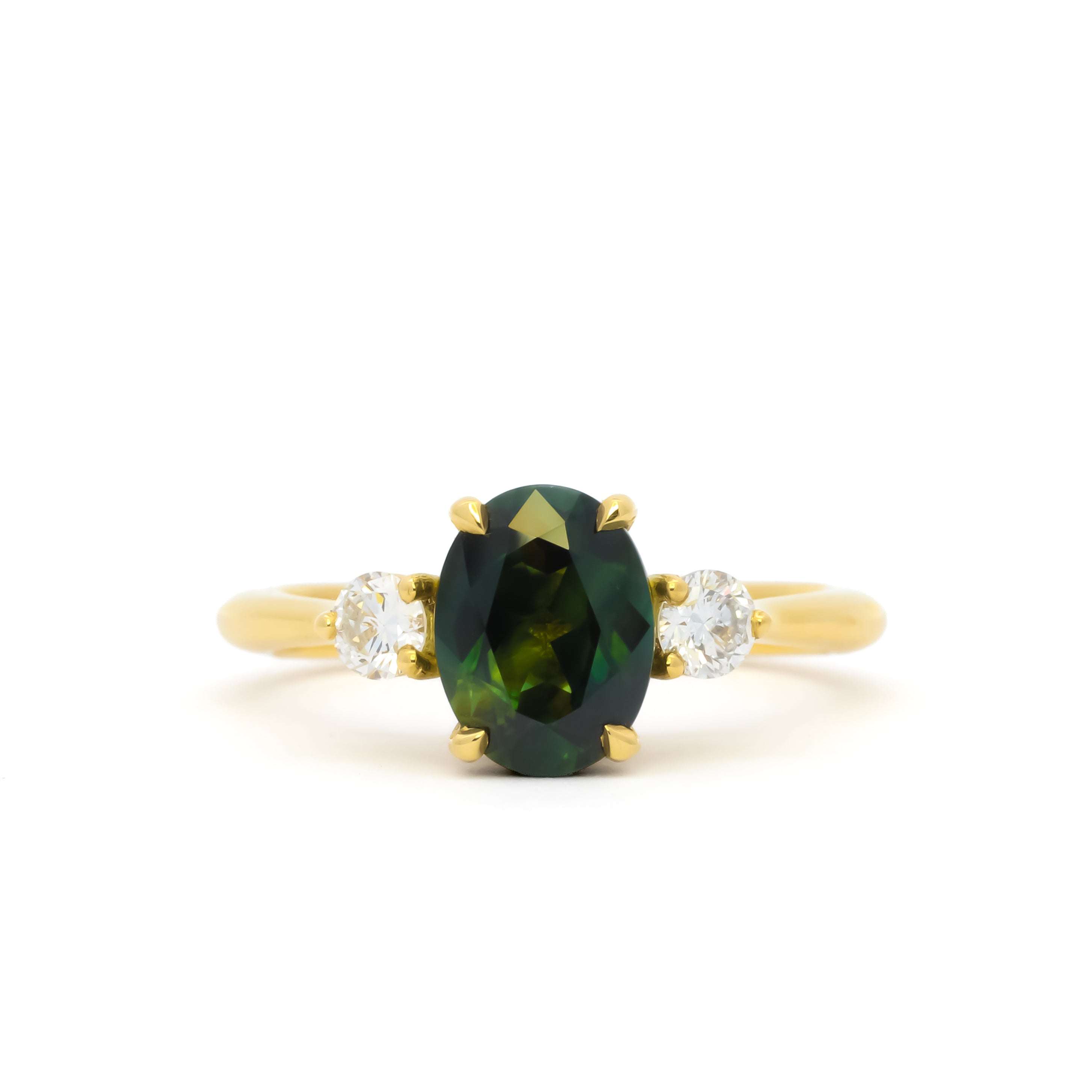 A yellow gold ring featuring an oval dark green sapphire in the center, flanked by two small round diamonds on either side of the band, set against a plain white background.