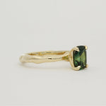 green engagement ring solitaire ring on white background side view