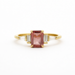 Gold ring with a pink gemstone on a white background