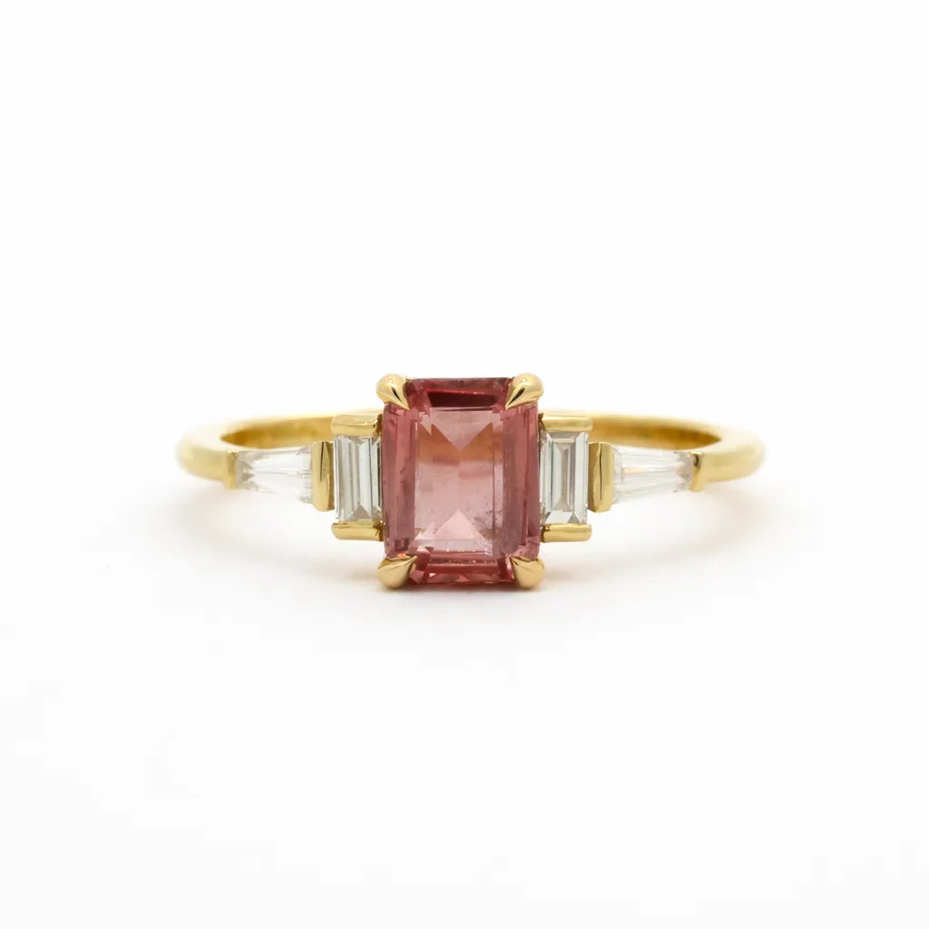 Gold ring with a pink gemstone on a white background